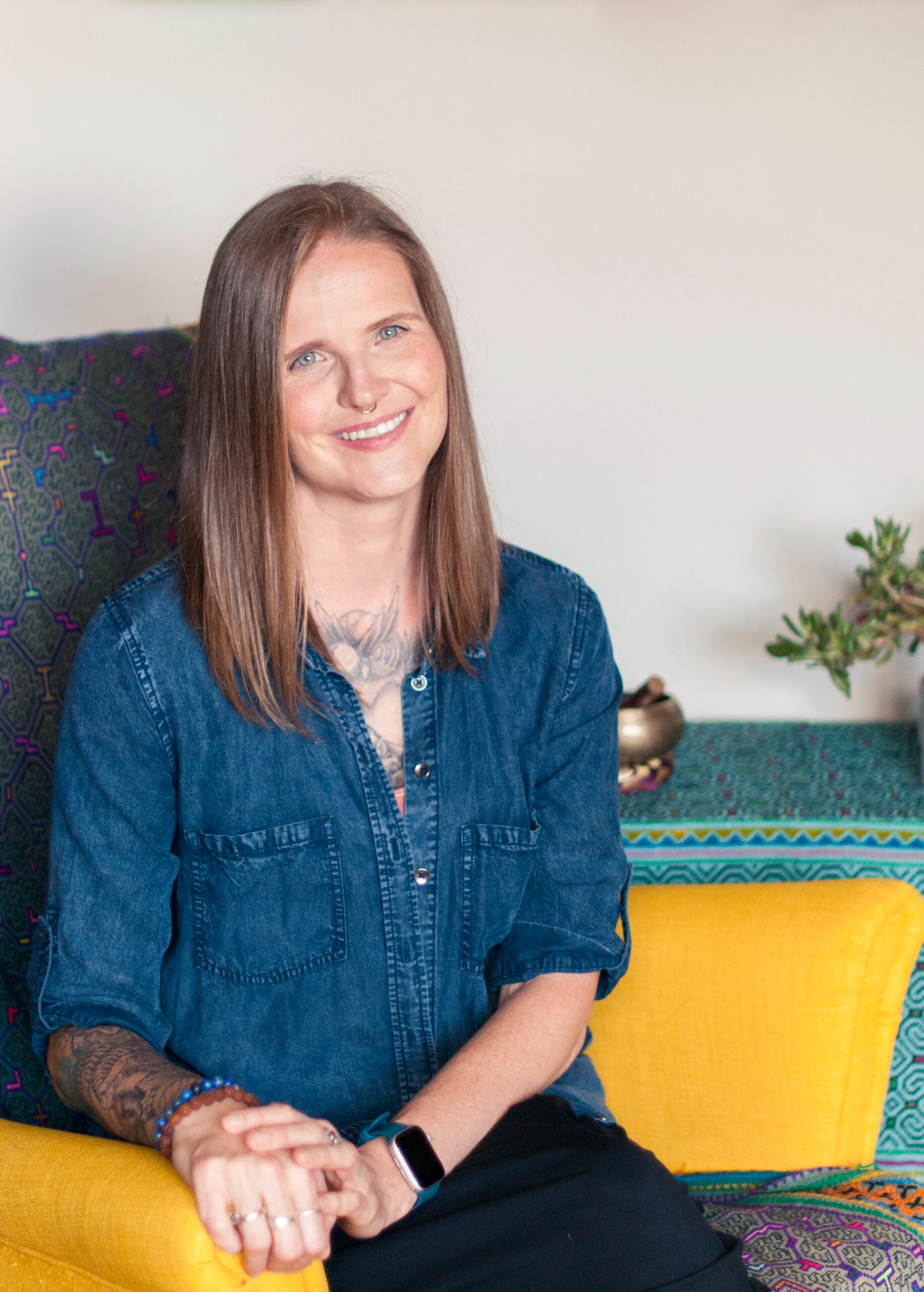 Dax Vorona, Certified Yoga Therapist from Toronto, seated in a calm studio setting, smiling.